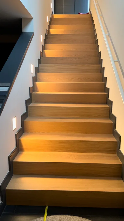 Escalera de peldaños de madera con balizas de luz · Ana Uría Interiorismo