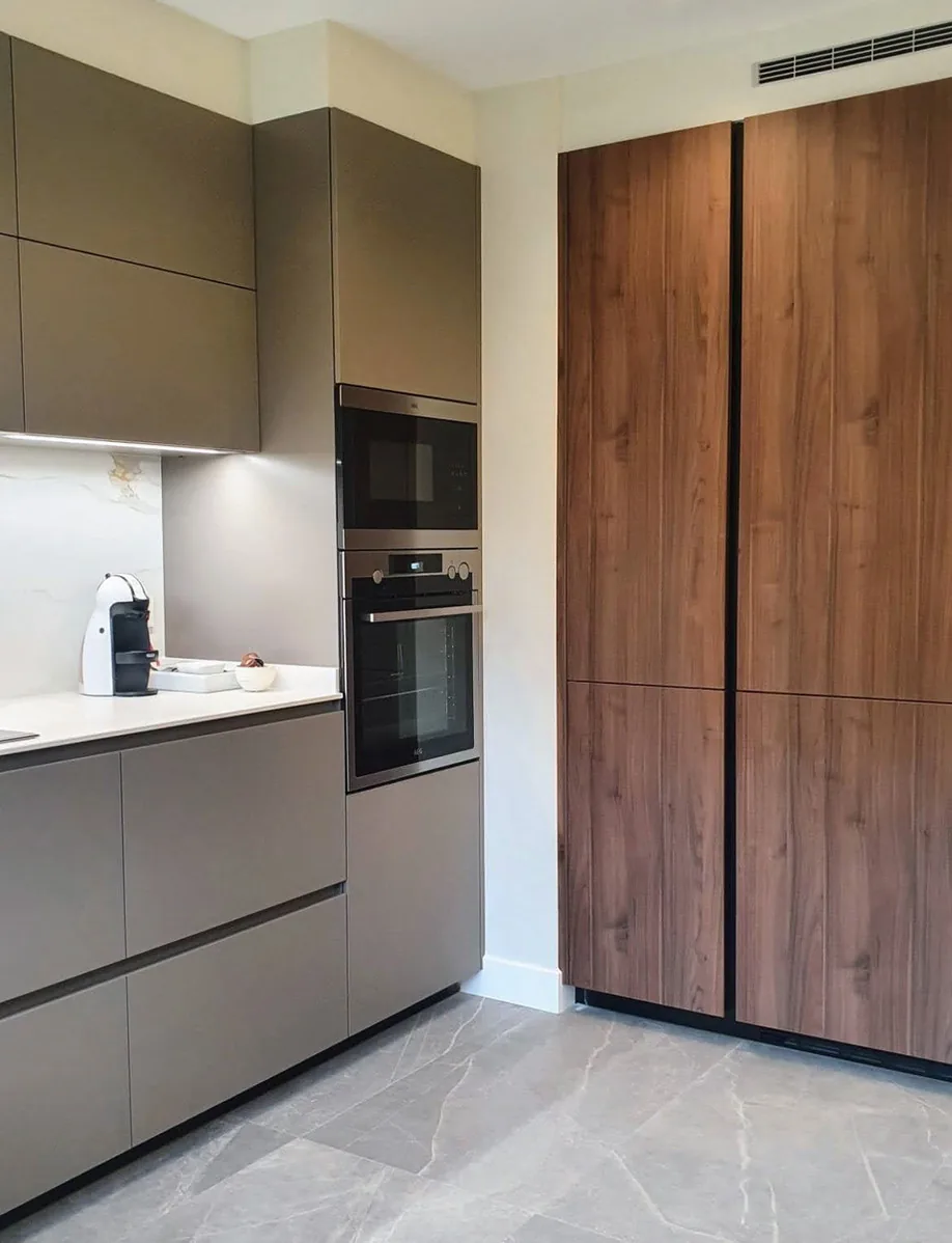 Cocina con columna de hornos y armario alto en madera de nogal · Ana Uría Interiorismo