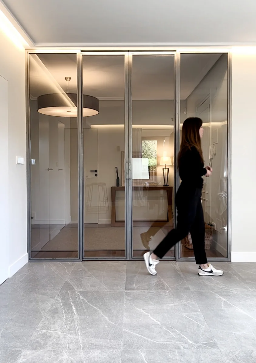 Cerramiento acristalado con perfilería negra en recibidor · Ana Uría Interiorismo